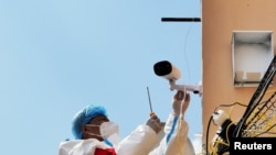 黑龙江省牡丹江市一个住宅小区里有身穿防护服的人在安装监控摄像头。(2022年4月14日)