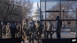 在当选总统拜登举行就职典礼前,华盛顿加强了安全戒备。正在进行交接班的国民警卫队员在国会大厦的背景下通过安全围栏。(2021年1月16日)