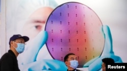 2021年3月17日,在中国上海举行的半导体技术大会上,人们参观半导体器件展示。