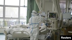 通过微博传出的中国武汉中心医院的医护人员正在治疗病人。(日期不详)