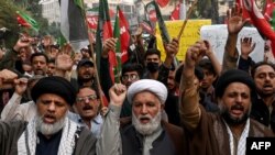 2024年11月22日,什叶派穆斯林举着标语并高呼口号在巴基斯坦拉合尔开伯尔-普什图省山区帕拉奇纳尔库拉姆区举行抗议教派袭击的游行。