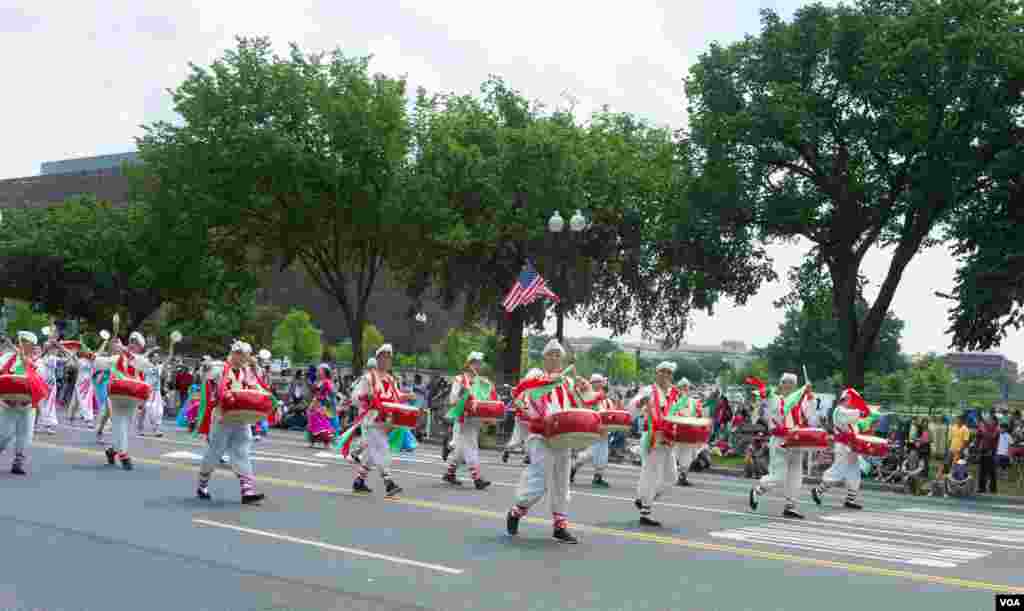 华人参加7曰4日美国首都华盛顿国庆游行(美国之音拍摄)。来自全美各地的行进乐队,花车和社区队伍走过华盛顿宪法大道,展示了美国爱国精神和多元文化。华盛顿独立节游行由国家公园管理处举办。参加游行的行进乐队通常由各州州长办公室或其他组织推荐,乐队要提交录像,照片等资料给组委会。选择标准包括整体水平,区域以及族裔代表性。