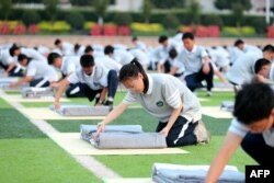 中国浙江省东阳市一所高中的学生在操场上军训时学习叠被子。(2024年8月15日)