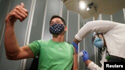 纽约市西奈山医院的Tommy Wong医生在接种辉瑞新冠病毒疫苗时伸出大拇指。(2020年12月15日)