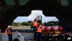 资料照片:在台湾东南部花莲空军基地的台湾军事人员准备将鱼叉反舰导弹装载到F-16V战机上。(2022年8月17日)