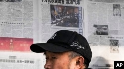 2023年2月6日,北京一男子阅读报刊有关中国间谍气球被美军击落的新闻报道后离开报亭。