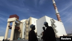 资料照:伊朗工人站在布什尔核电站前。