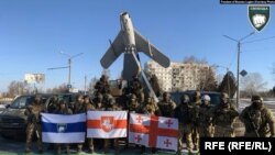 Бійці легіону "Свобода Росії", бійці полку імені Кастуся Калиновського та грузинські добровольці. "Тихий" тримає прапор легіону, "Цезар" – праворуч від нього. Фото: RFE/RL