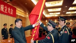 资料照片:中国官方公布的照片显示,中共领导人习近平在北京举向时任火箭军首届司令的魏凤和上将授予军旗。(2015年12月31日)