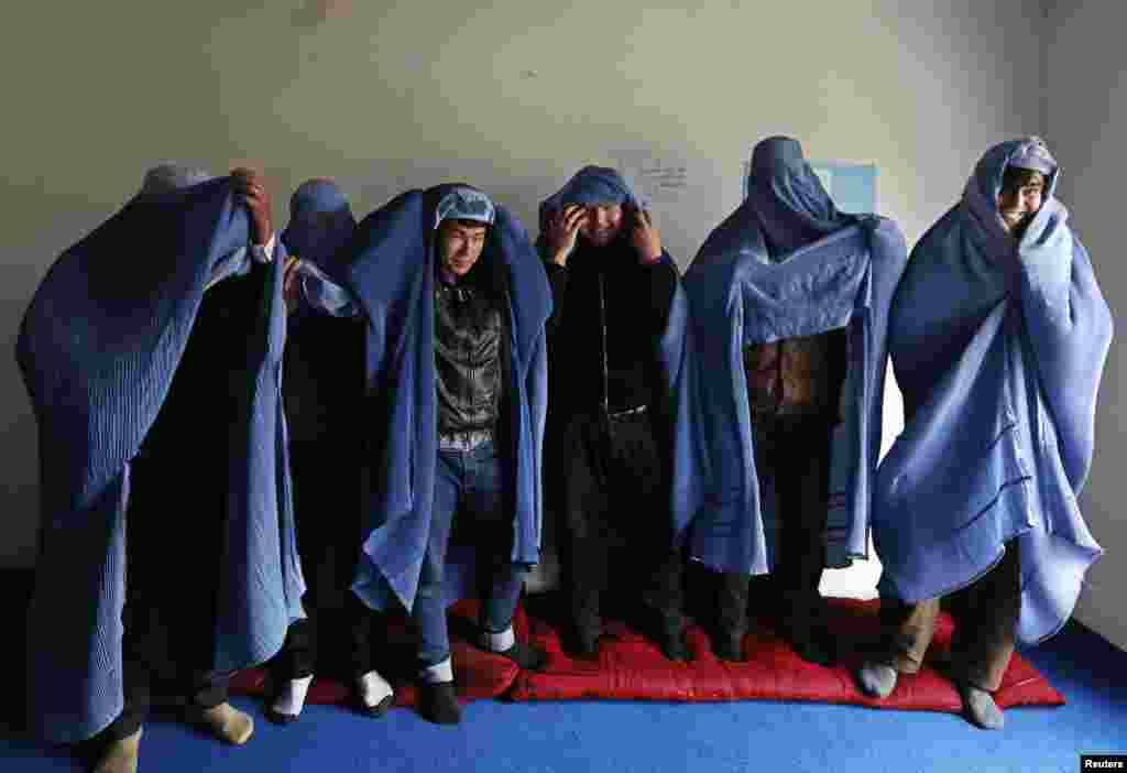 Male Afghan women's rights activist wear burqas to show their solidarity with Afghan women ahead of International Women's Day in Kabul, March 5, 2015.