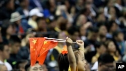 一个小女孩在上海举着两面中国国旗观看布鲁克林篮网队和洛杉矶湖人队的篮球比赛。(2019年10月10日)