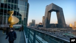 一名戴着口罩的男子在中国官媒中央电视台总部大楼附近的观景台行走。(2021年2月4日)