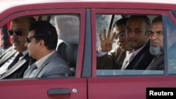 穆斯林兄弟会及被推翻的总统穆尔西的律师乘车抵达审判现场并打出手势。(2013年11月4日)