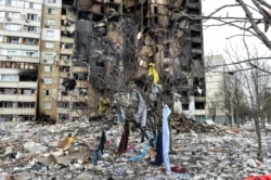 This picture shows an apartment building damaged after shelling the day before in Ukraine's second-biggest city of Kharkiv on March 8, 2022.