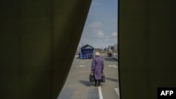 2022年4月5日,一名妇女在抵达位于马里乌波尔西北约200公里(124英里)的扎波罗热的流离失所者中心后站在帐篷外。(法新社)