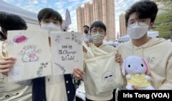 香港皇仁书院年宵筹委会主席伍正枫(右一)及成员Anthony (中)展示他们一班同学今年在荃湾南丰纱厂年宵市集售卖的自家设计”白玉兔“产品。 (美国之音 汤惠芸)