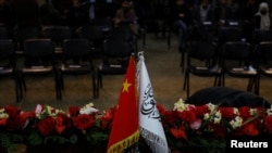 2023年1月5日,中国驻阿富汗大使王愚和阿富汗塔利班政权临时副总理毛拉·阿卜杜勒·加尼·巴拉达尔在喀布尔举行的新闻发布会的会场上展出的中国国旗和“阿富汗伊斯兰酋长国”(塔利班政权)的旗帜。