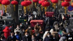 北京后海一条熙熙攘攘的街道,传统的三轮儿在人群中穿行。(2023年1月30日)