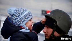 စစ်ဘေးလွတ်ရာ မိသားစုနဲ့အတူထွက်ခွါတော့မယ့် သားငယ်ကိုနှုတ်ဆက်နေတဲ့ဖခင် ယူကရိန်းရဲအရာရှိတဦး (မတ်လ ၈၊ ၂၀၂၂)