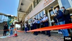 香港警方在距离北京驻港机构中联办超过100米的一间餐厅门外,拉起封锁线设立“示威区”,禁止两名社民连成员靠近中联办示威 (美国之音/汤惠芸)