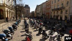 资料照片:乌克兰利沃夫市议会外摆放着109个空空的婴儿推车和摇篮,象征俄军入侵乌克兰迄今被夺去生命的109名儿童。(2022年3月18日)