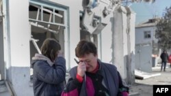 乌克兰南部城市尼古拉耶夫的护士们赶到现场目睹她们的医院遭俄军炮击破坏的景象后失声痛哭。(2022年3月22日)