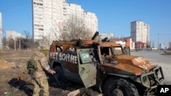 资料照片:乌克兰军人在哈尔科夫查看一辆在最近的战斗中被摧毁的俄罗斯军车。(2020年3月24日)