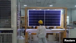 资料照:2019年12月10日,一名工人在中国陕西省西安市一家单晶硅太阳能设备制造商的工厂对太阳能组件产品进行质量检查。(路透社)