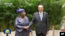 2022年12月8号,中国总理李克强和世界贸易组织总干事恩戈齐·奥孔乔-伊维拉在中国安徽黄山举行会谈前握手拍照。随着中调整其新冠对抗政策,中国有信心使经济恢复持续发展。照片发自中国中央电视台,由美联社提供。