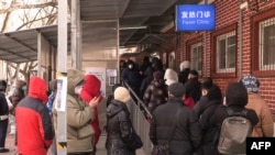 北京一家医院发热门诊外排长队的市民。(2022年12月14日)