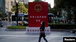 一名女子走过上海街头宣传中国宪法的宣传牌。（2021年11月12日）