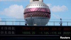 资料照:上海陆家嘴金融区的一块电子显示屏在显示即时日经与恒生指数的股市信息。(2022年10月25日)