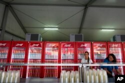 国际足联举办的第22届世界杯足球赛将于星期日(11月20日)在卡塔尔首都多哈市进行比赛。周六(11月19日),两位妇女正在为安放在球迷区自动啤酒贩售机补货。