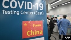 韩国仁川国际机场的医护人员为从中国抵达的乘客进行核酸检测。(2023年1月3日)