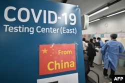 韩国仁川国际机场的医护人员为从中国抵达的乘客进行核酸检测。(2023年1月3日)