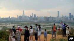 资料照:游客来到香港和中国大陆的边界遥望远处的深圳。(2021年2月13日)