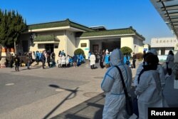 身穿防护服的上海民众站在一家火葬场外。(2022年12月24日)