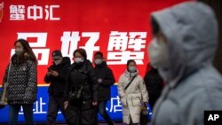 北京民众走出朝阳区CBD金融区的一个地铁站。(2023年1月12日)