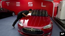 资料照:北京特斯拉电动车专卖店的工作人员在为特斯拉首批销售做准备。(2018年10月17日)