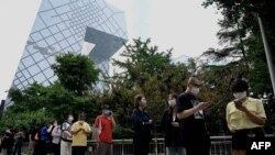 人们在北京的央视大楼旁排队等候进行新冠核酸检测。(2022年6月13日)