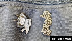陈小姐在背包上掛上”毋忘初心”徽章。(美国之音/汤惠芸)