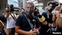 遭香港警方以“阻差办公”罪名正式落案起诉的香港记者协会(HKJA)主席、网媒记者陈朗升抵达旺角警署。(2022年9月19日)