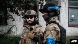 乌克兰警察冒雨在库普扬斯克城镇执勤(2022年9月24日)