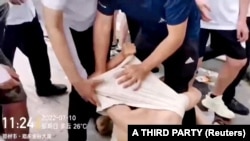 中国河南村镇银行储户在郑州抗议期间,便衣警察拖拽抗议者时把他的衣物拉起套住头部。(2022年7月10日)