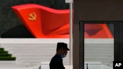 2022年5月26日,北京一名保安站在中国共产党博物馆的中国共产党党旗雕塑旁。(资料照片)