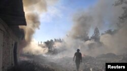 乌克兰一名救援人员在顿涅茨克地区托列茨克镇被俄军炸毁的住宅区废墟中行走。(2022年7月27 日)