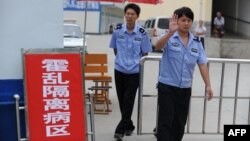 资料照:安徽省蒙城县当年有38人感染霍乱,警察在阻止人们靠近一所用于隔离的学校。(2010年9月3日)