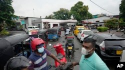 People wait in a long queues to buy fuel for their vehicles at a filling station in Colombo, Sri Lanka, June 11, 2022.