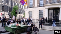 示威者把纸扎坦克摆在中国驻英大使馆外,并且把纸扎坦克的炮口指向大使馆。 (美国之音郑乐捷)