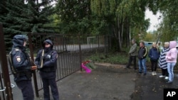 俄罗斯9月26日发生两起枪击案,其中一起发生在俄罗斯中西部乌德穆尔特共和国首府伊热夫斯克第88学校,图为枪击案现场有人献花,有人驻足表示哀悼。第88学校的枪击案造成13人死亡,其中有7名儿童,另外还有21人受伤。-美联社照片